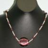 Glass, wood, and silver bead necklace with vibrant glass pendant. Class collection. 20" long. $35